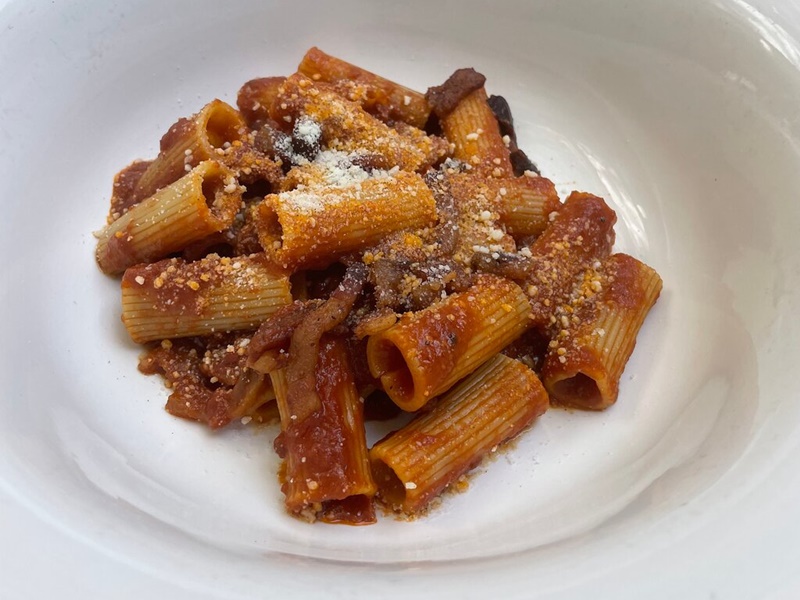 Plate of tomato-based Amatriciana pasta served during a golf cart Rome food tour